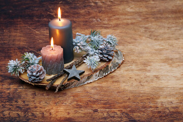 Romantische Advents Dekoration mit Kerzen,Zweigen und Weihnachtsschmuck auf einer Baumscheibe...