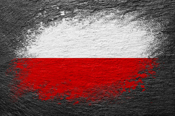 Flag of Poland. Flag is painted on a stone surface. Stone background. Black slate background