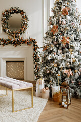 christmas decor. A Christmas tree in a beautifully decorated living room on the background of a fireplace. White interior.