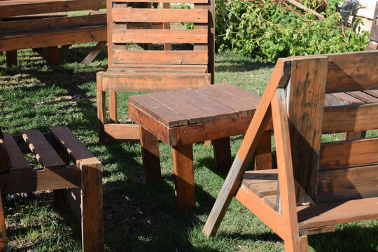 Wooden chairs with a small table on the grass. Space to rest and relax.