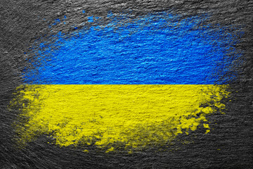 Flag of Ukraine. Flag is painted on a stone surface. Stone background. Black slate background