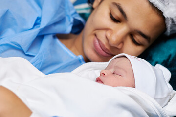 emotional shot of a mother and her newborn cute baby after the birth, 