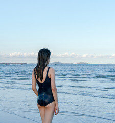 Woman in swimsuit standing by the sea