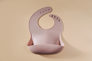 Brown silicone baby bib. First baby accessories for dinner. Top view, flat lay