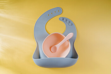 Blue silicone baby bib and and bowl. Serving baby. First baby accessories for dinner.  Top view,...