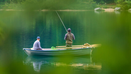 Zwei Angler in einem kleinen Boot auf einem idyllischen See