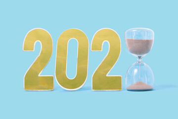 Combination of two and zero numbers with a sand clock at the end on the blue background. Happy new year abstract concept.