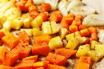 Oven-baked vegetables on a baking sheet. Baked pumpkin, potatoes, carrots and onions. Cooking dinner in the oven. Vegetarian food in the oven. Vegan cuisine. Proper and healthy nutrition
