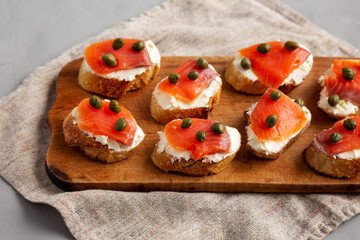 Homemade Lox And Cream Cheese Crostini on a wooden board, side view.