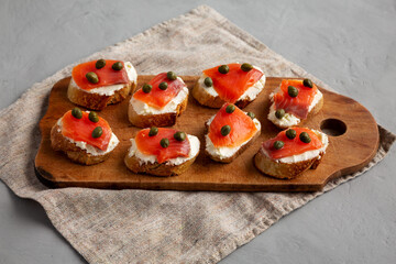 Homemade Lox And Cream Cheese Crostini on a wooden board, low angle view.