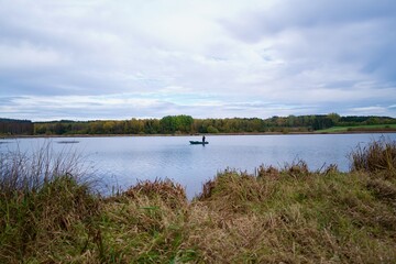 fisherman on a lake standing at his boat