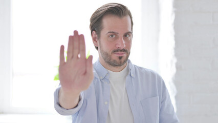 Portrait of Rejecting Young Man Showing Stop Sign