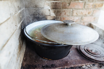 Cooking in the oven in the backyard. The fire is lit in a summer brick oven.