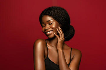 Happy. Beauty portrait of young african american woman posing against red background