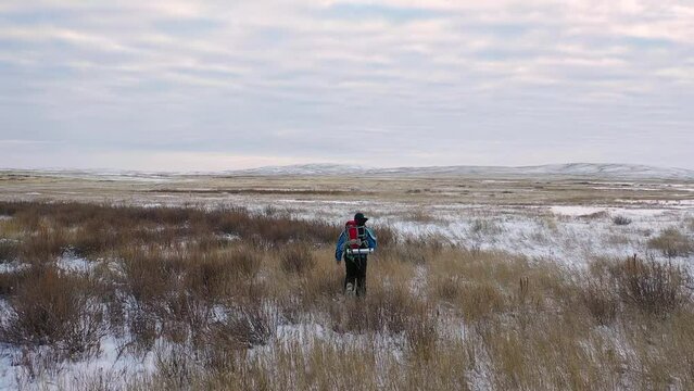 Lonely man walking through snowy desert. Aerial FHD slow motion footage. FHD slow motion video.