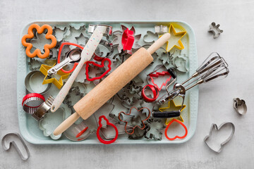 A cookie sheet filled with cookie cutters and other various baking tools. - Powered by Adobe