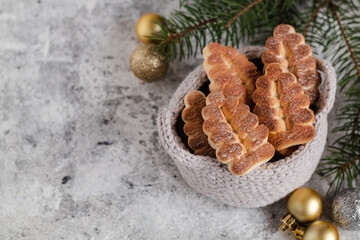 Christmas compsition with crochet basket, shortbread cookies, baubles and fir tree branches. Copy space.