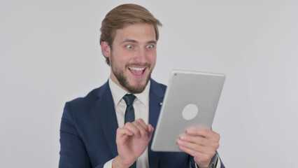 Young Businessman Celebrating Success on Tablet on White Background