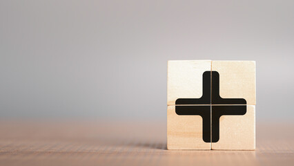 Plus sign in wooden cube block stack. added value, benefits, additional, personal development,...