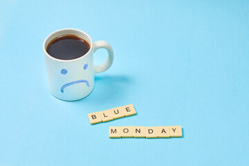 Blue monday, cup of coffee with a sad face.