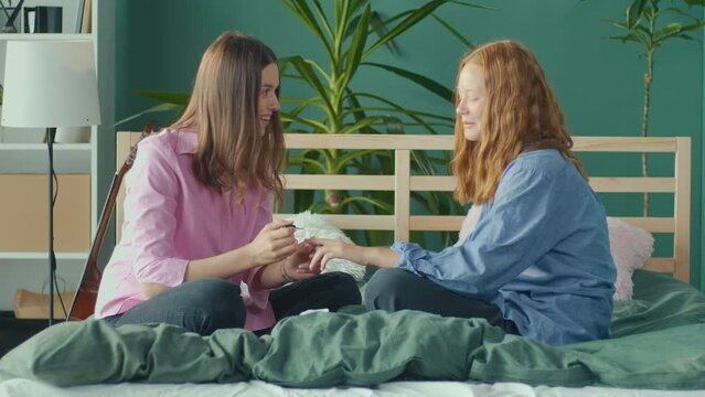 Girlfriends, Students Sit at Home on Bed and Paint Nails. Two Sisters Having Fun, Chatting, Body Positive. Adolescence Concept. Mental Health.