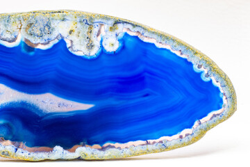 Vibrant deep blue and semi-transparent agate geode slice crystal, banded chalcedony stone isolated...
