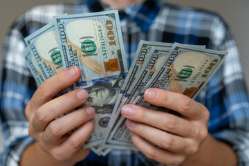 Female person counting American one hundred dollar bills close up.