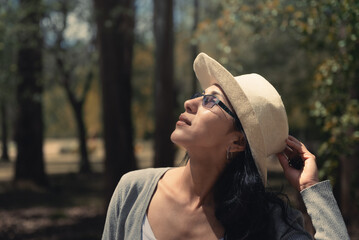 mujer con sombrero disfrutando de la naturaleza en bosque