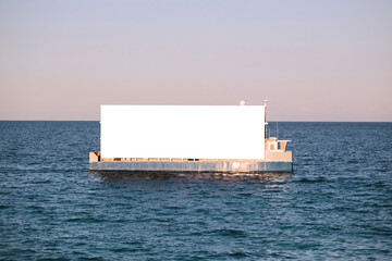 Boat with an advertising white billboard mock up floating on the sea for marketing BTL campaign
