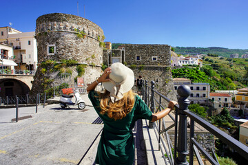 Tourism in Calabria. Back view of beautiful woman in Pizzo with Murat Aragon Castle in Pizzo,...