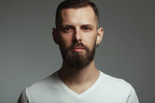 Male beauty concept. Portrait of proud charismatic active 30-year-old man posing over dark gray background looking at camera. Perfect haircut. Hipster style. Close up. Studio shot