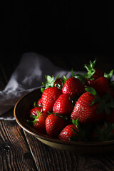 A bowl with ripe bright strawberry in rustic style