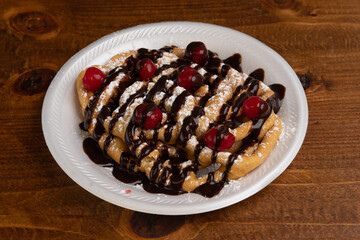 Funnel cake with chocolate sauce and cherries