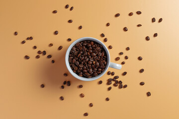 Top view of coffee beans in white cup on yellow background