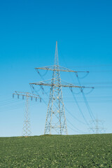 Energieknappheit, Strommast auf Feld vor blauem Himmel