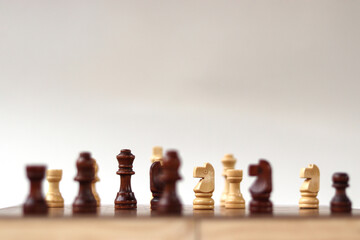 A chessboard with walking figures placed on a white background. Strategy game.