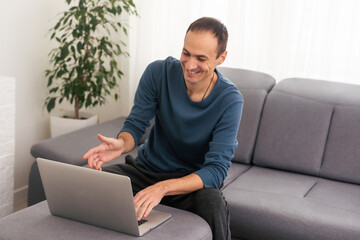 Young male tech user relaxing on sofa holding laptop computer mock up blank white screen. Man using modern notebook surfing internet, read news, distance online study work concept.