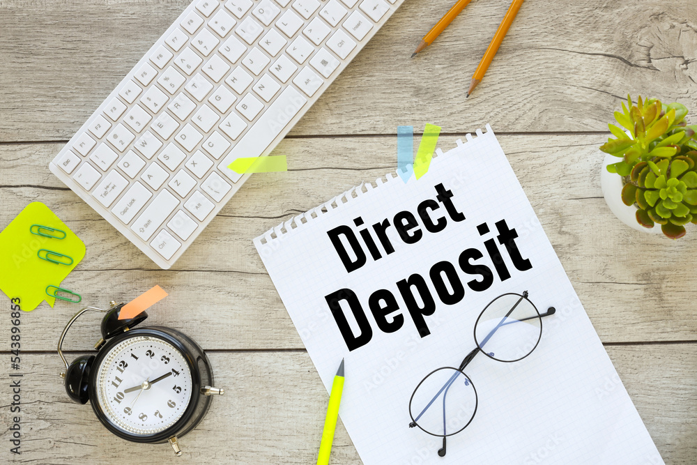 Poster direct deposit. white keyboard on a light desktop. text on notebook . business concept image