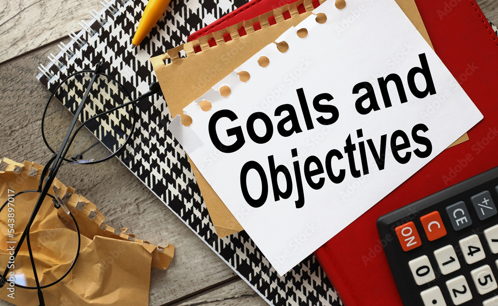 Poster goals and objectives words in a notepad next to the calculator.