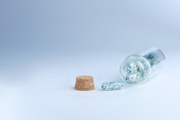 Medical capsules in a glass bottle on a blue background