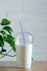 milkshake stands on a table against a white wall
