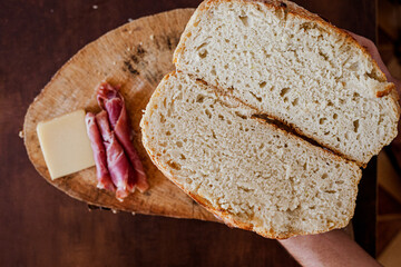 pão italiano artesanal com presunto de parma e queijo parmesão na tábua de madeira