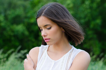 Naklejka premium Young woman in white dress standing in the nature on a beautiful summer day