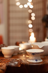 Blurred background - Japanese tea party, close-up of white utensils on a wooden tray, cozy atmosphere by candlelight