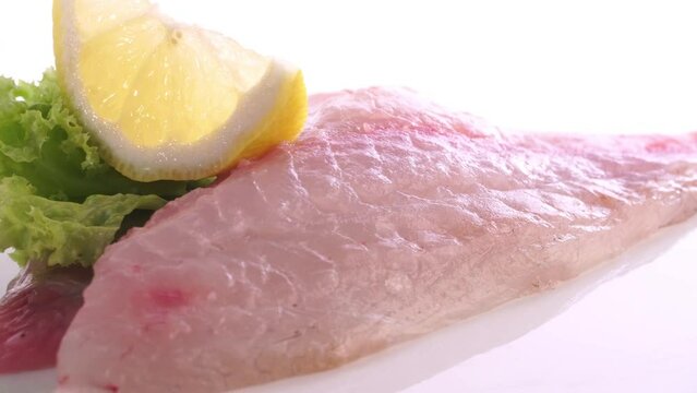 Raw Sea Bream Fish Fillet with Lemon turn around isolated on white Background