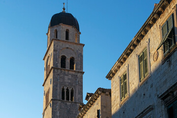 Detail of church and bell tower of the Franciscan church in clear sunny day at sunset in Dubrovnik,...