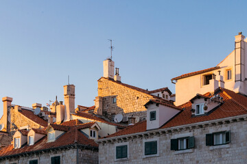 Details of walls, roof tiles and windows of yellow, orange and brown houses as seen in sunny day in...