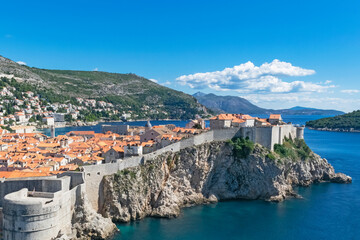 Fototapeta na wymiar Aerial skyline panoramic view of Dubrovnik old town at sunset featuring brown, orange and yellow roofs. Vintage or holiday travel background. Dubrovnik, Croatia. 