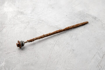Worn magnesium anode to protect an electric water heater from rust on a gray concrete background.