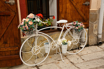 Bicicleta blanca retro con ramos de flores.